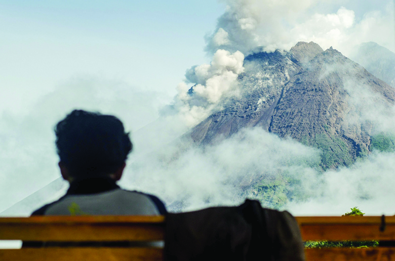 SLEMAN, Yogyakarta, Indonesia: A villager looks at Mount Merapi, Indonesia's most active volcano, as seen from Sleman, on December 2, 2021. -- AFPnn