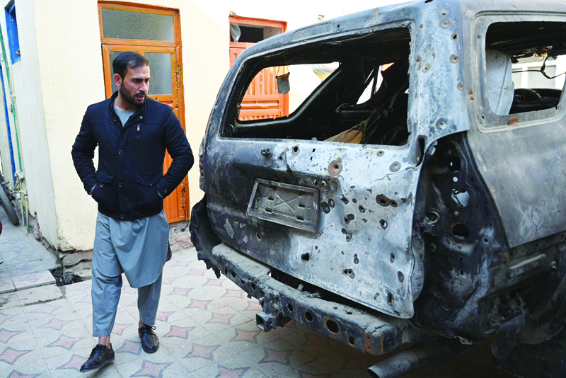 KABUL: Aimal Ahmadi, whose daughter Mailka and his elder brother Zimarai Ahmadi was among 10 relatives killed by a wrongly directed US drone strike on August 29, stands near a car, which was damaged during the strike, outside his house in Kabul yesterday. - AFPnn