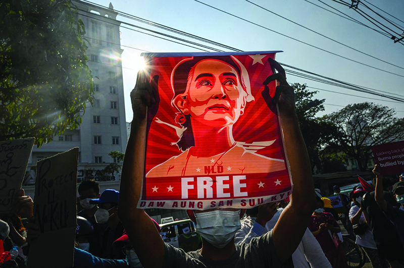 YANGON: File photo shows a protester holding up a poster featuring Aung San Suu Kyi during a demonstration against the military coup in front of the Central Bank of Myanmar in Yangon. — AFP