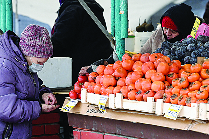 MOSCOW, Russia: A woman buys fruits at a market in Moscow.—AFP