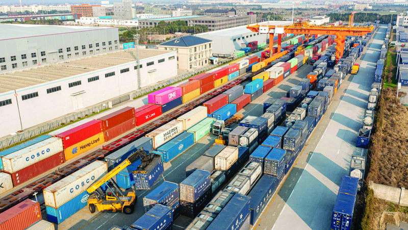 Aerial photo taken on December 6, 2021 shows large lifting equipment hoisting containers onto a train at the railway Logistics base in Nantong, Jiangsu Province, China.n