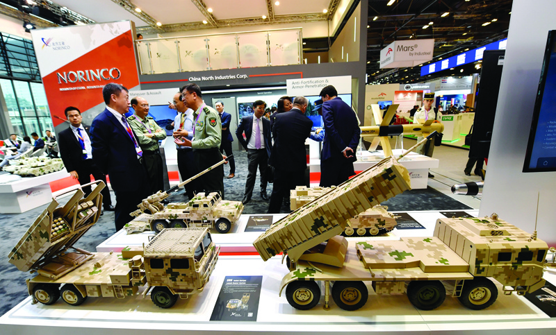 VILLEPINTE, France: In this file photo taken on June 11, 2018 visitors speak to military personnel as they stand in front of models of military vehicles manufactured by the Chinese company Norinco, displayed at the Eurosatory Defense and Security international exhibition in Villepinte, near Paris. -- AFPnn