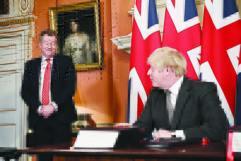 LONDON, UK: In this file photo taken on December 30, 2020 UK chief trade negotiator, David Frost (left) looks on as Britain’s Prime Minister Boris Johnson signs the Trade and Cooperation Agreement between the UK and the EU, the Brexit trade deal, at 10 Downing Street in central London. —AFP