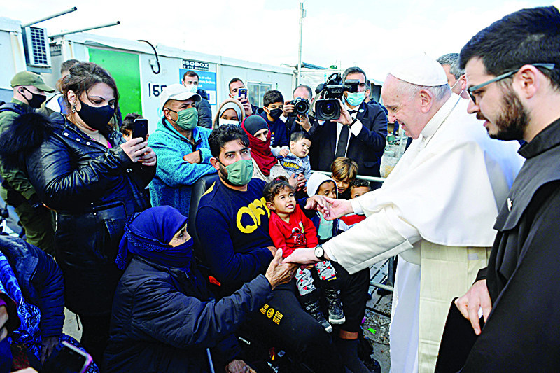 MYTILENE, Lesbos: This handout photograph taken yesterday and released by Vatican Media shows Pope Francis (2R) meeting refugees at the Reception and Identification Centre in Mytilene on the island of Lesbos. - AFPnnnn