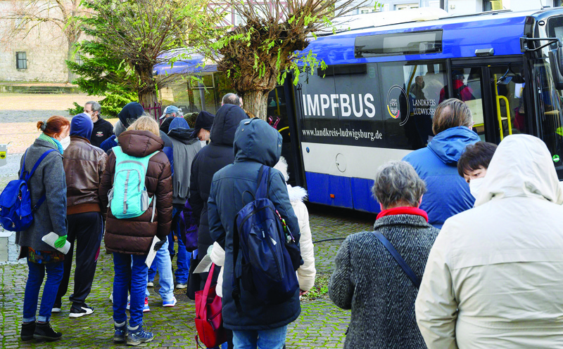 LUDWIGSBURG, Baden-Wurttemberg, Germany: People stand in a queue as they wait for their COVID 19 vaccination in a vaccination bus, a mobile vaccination center in Hemmingen near Ludwigsburg, southern Germany, yesterday. - AFPnnn