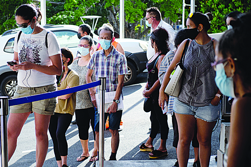 NOUMEA: Residents wait to vote for the referendum on independence outside a polling station of the City Hall in Noumea, on the French South Pacific territory of New Caledonia yesterday. - AFPnnn