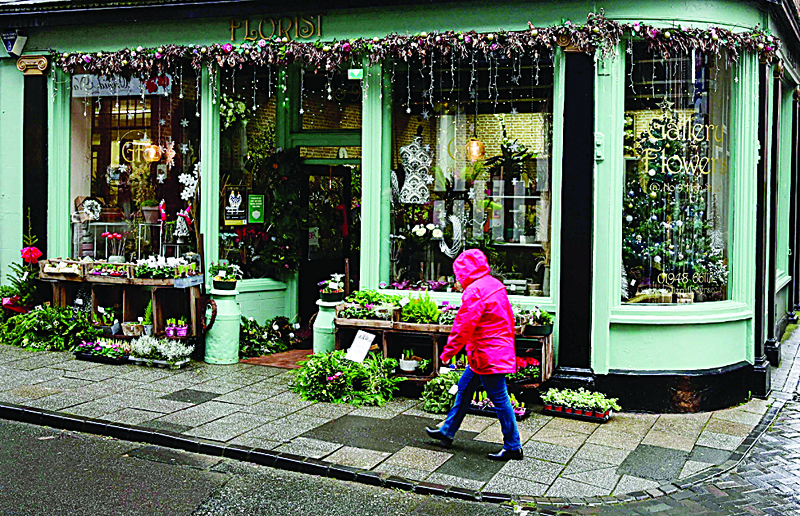 WHITCHURCH, United Kingdom: A pedestrian walks past Christmas decorations in a shop in Whitchurch, central England, ahead of a by-election in the North Shropshire constituency tomorrow. - AFPnnn