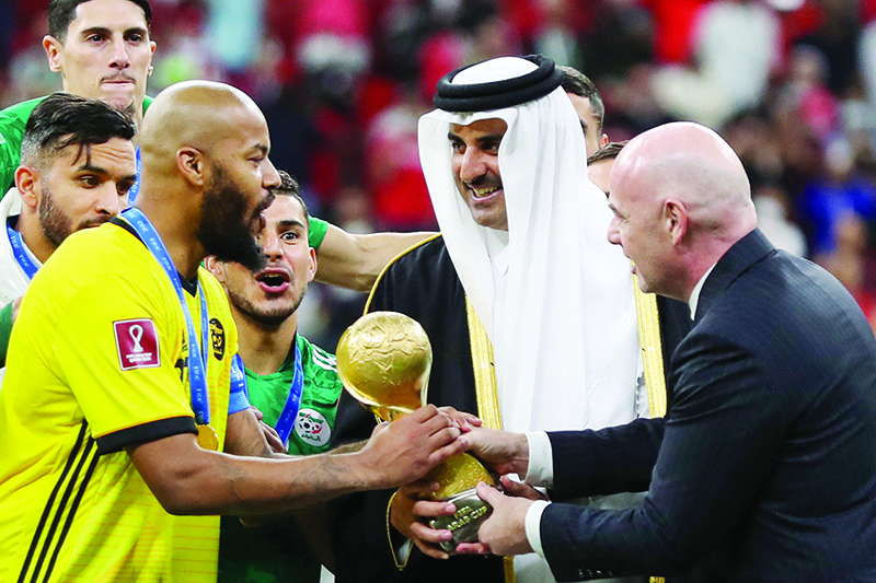 AL-KHOR, Qatar: Qatar’s Amir Sheikh Tamim bin Hamad Al-Thani and FIFA President Gianni Infantino present Algeria’s goalkeeper and captain Rais M’Bolhi with the FIFA Arab Cup 2021 trophy at the Al-Bayt stadium on Saturday. — AFP