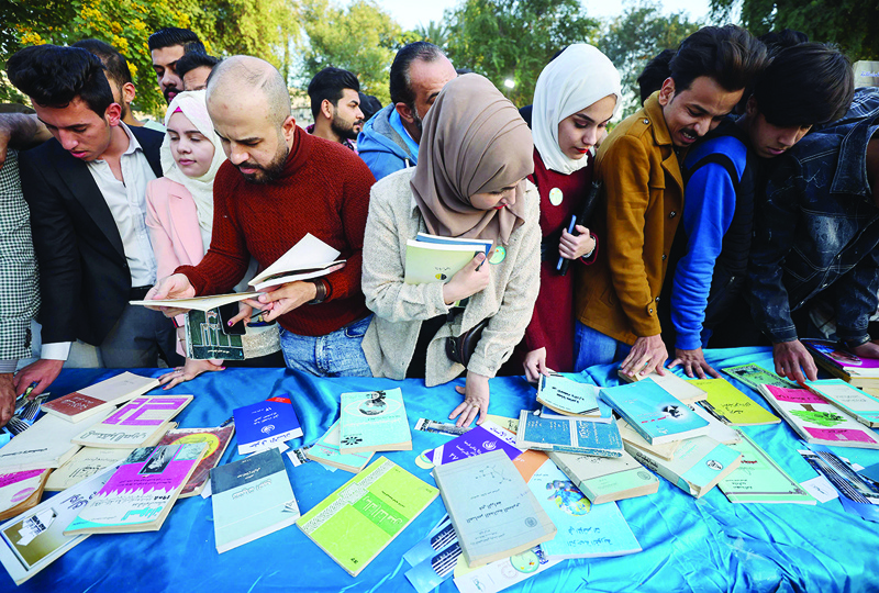 BAGHDAD: Iraqis look through books during an annual cultural festival in the capital Baghdad's Abu Nawas street. - AFP n