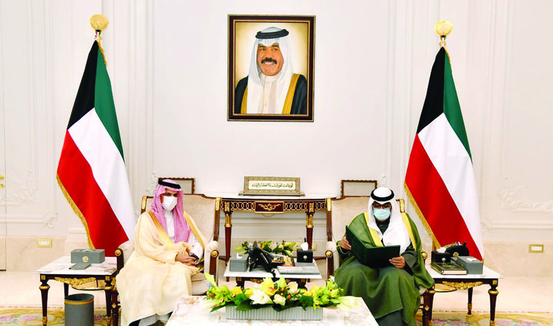 KUWAIT: His Highness the Crown Prince Sheikh Mishal Al-Ahmad Al-Jaber Al-Sabah reads the invitation while meeting Saudi Foreign Minister Prince Faisal bin Farhan Al-Saud. - KUNAn