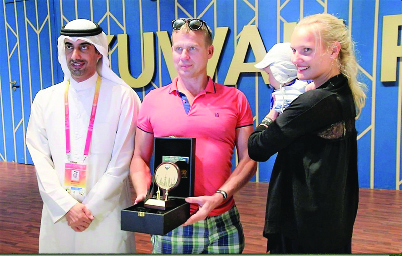 DUBAI: Kuwait pavilion's director Bader Al-Enezi (left) presents a commemorative shield to Vambola Varda (center), the pavilion's one millionth visitor. - KUNAnnn