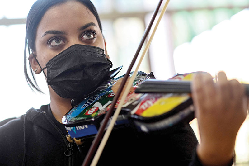 Cristina Vazquez, 18 years old, member of the 'Music of Recycling' orchestra, plays violin during a rehearsal.