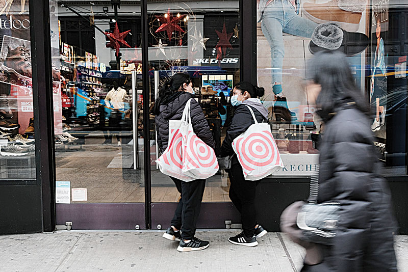 NEW YORK: In this file photo, shoppers stand outside a store in Manhattan. — AFP