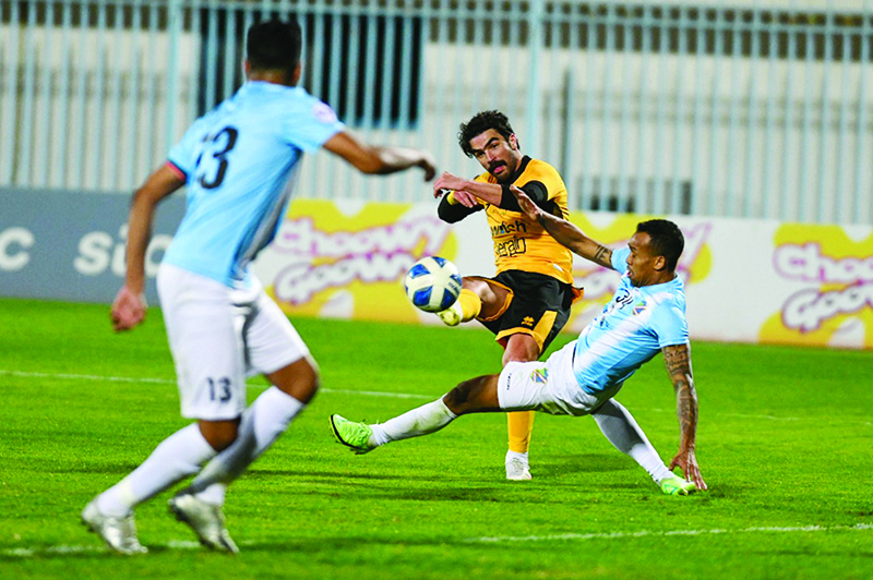 KUWAIT: Qadsia’s Ahmad Al-Reyahi (center) shoots the ball during his team’s Kuwait Premier League match against Salmiya on Sunday. — KUNA
