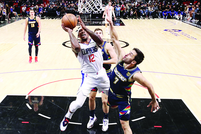 LOS ANGELES: Eric Bledsoe #12 of the Los Angeles Clippers drives to the basket against Facundo Campazzo #7 of the Denver Nuggets during the third quarter at Crypto.com Arena on December 26, 2021. — AFP