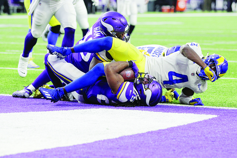 MINNEAPOLIS: Alexander Mattison #25 of the Minnesota Vikings falls into the end zone for a rushing touchdown against Jalen Ramsey #5 and Jordan Fuller #4 of the Los Angeles Rams in the third quarter at US Bank Stadium on December 26, 2021. — AFP