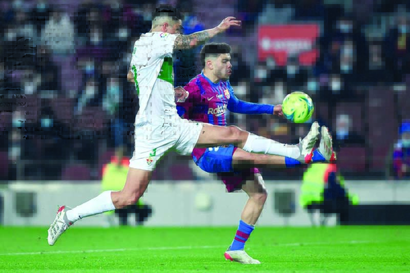 BARCELONA: Elche’s Chilean defender Enzo Roco (left) vies with Barcelona’s Moroccan forward Abde Ezzalzouli during the Spanish league football match between FC Barcelona and Elche CF at the Camp Nou stadium on December 18, 2021. —AFP