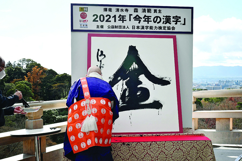 Seihan Mori, master of the ancient Kiyomizu temple writes the Chinese character, known in Japan as 'kanji', for 'gold', which was selected as the single best kanji to symbolize the year of 2021 at the temple in Kyoto. - AFP n