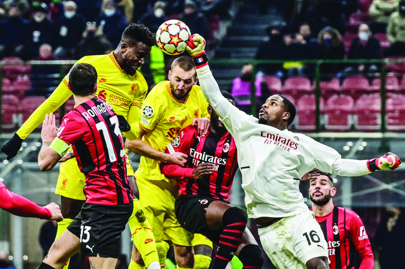 MILAN: Liverpool's Belgian forward Divock Origi (Top left) and AC Milan's French goalkeeper Mike Maignan (right) go for the ball during the UEFA Champions League Group B football match between AC Milan and Liverpool on December 7, 2021. - AFP n
