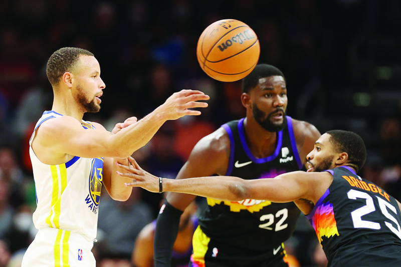 PHOENIX: Stephen Curry #30 of the Golden State Warriors passes the ball around Mikal Bridges #25 of the Phoenix Suns during the second half of the NBA game at Footprint Center on November 30, 2021. The Suns defeated the Warriors 104-96. - AFP n