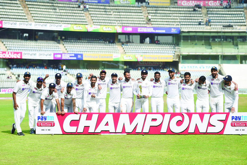 MUMBAI: India's cricketers pose for pictures with the trophy after winning the fourth day of the second Test cricket match between India and New Zealand at the Wankhede Stadium yesterday. - AFP  n