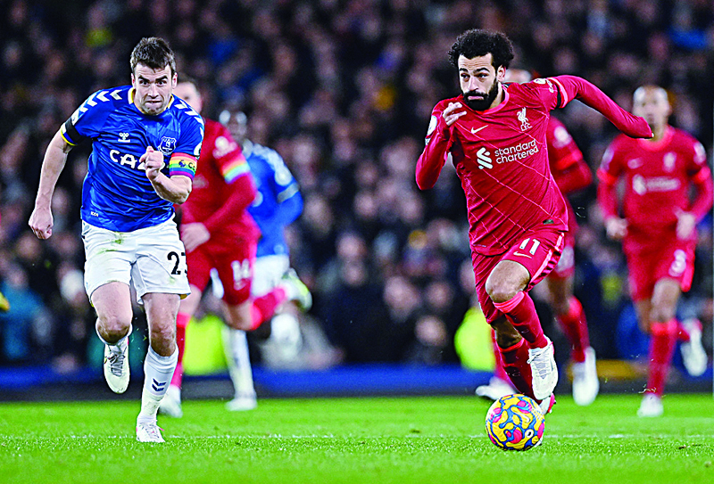 LIVERPOOL: Liverpool's Egyptian midfielder Mohamed Salah (R) runs past Everton's Irish defender Seamus Coleman to scores his team's third goal during the English Premier League football match between Everton and Liverpool at Goodison Park in Liverpool. - AFPn