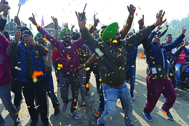 SINGHU, India: Farmers cheer as they prepare to leave the protest site at the Delhi-Haryana state border in Singhu yesterday, as Indian farmers formally ended year-long mass protests after Prime Minister Narendra Modi abandoned his push for agricultural reforms. - AFPnnnn