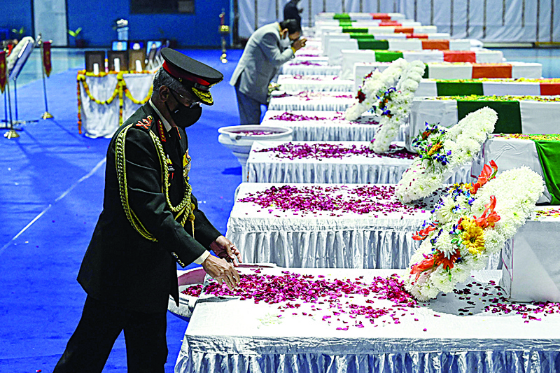 NEW DELHI: India's Army General Manoj Mukund Naravane pays his tribute in front of the coffins containing the mortal remains of Chief of Defence Staff Gen Bipin Rawat and other 12 victims who lost their lives in a helicopter crash. - AFPnn