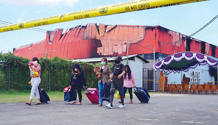 SORONG, West Papua: Employees leave Double O nightclub where at least 18 people were killed in clashes between two groups, in Sorong in Indonesia's West Papua province yesterday. - AFP