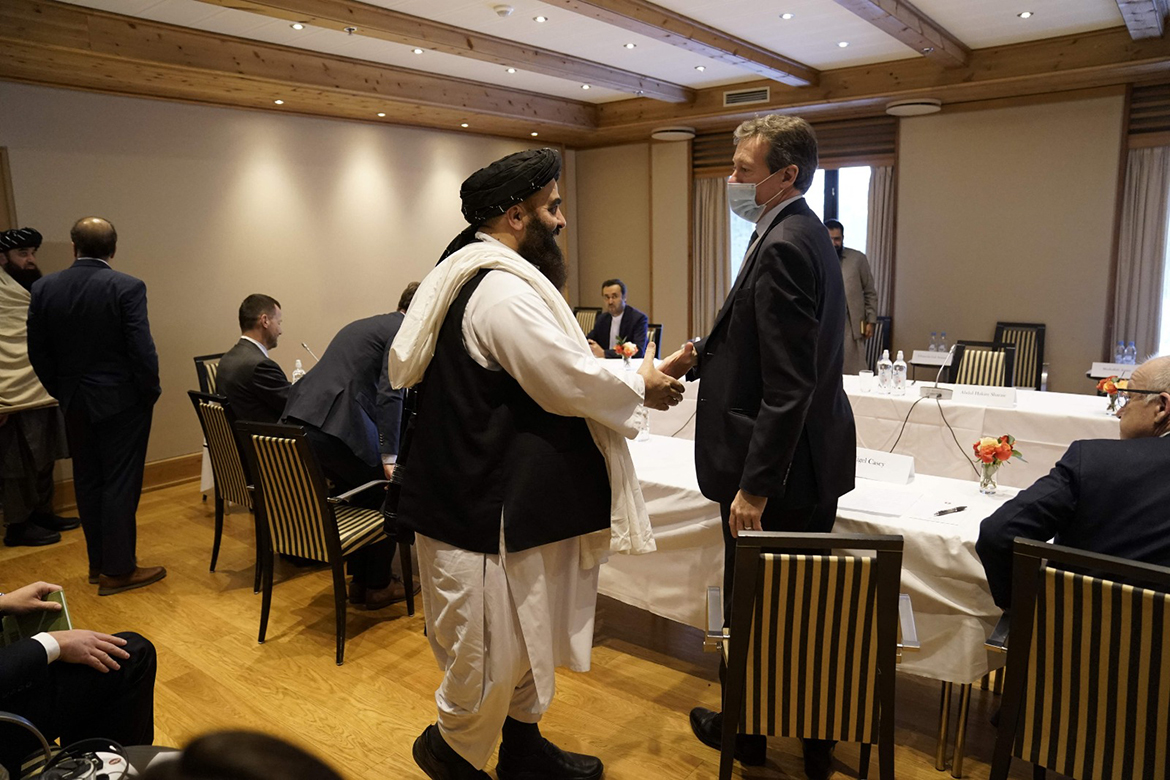 OSLO: Britain's Special Representative for Afghanistan Nigel Casey and Taleban representative Amir Khan Muttaqi shake hands as they arrive to attend a meeting yesterday. – AFP