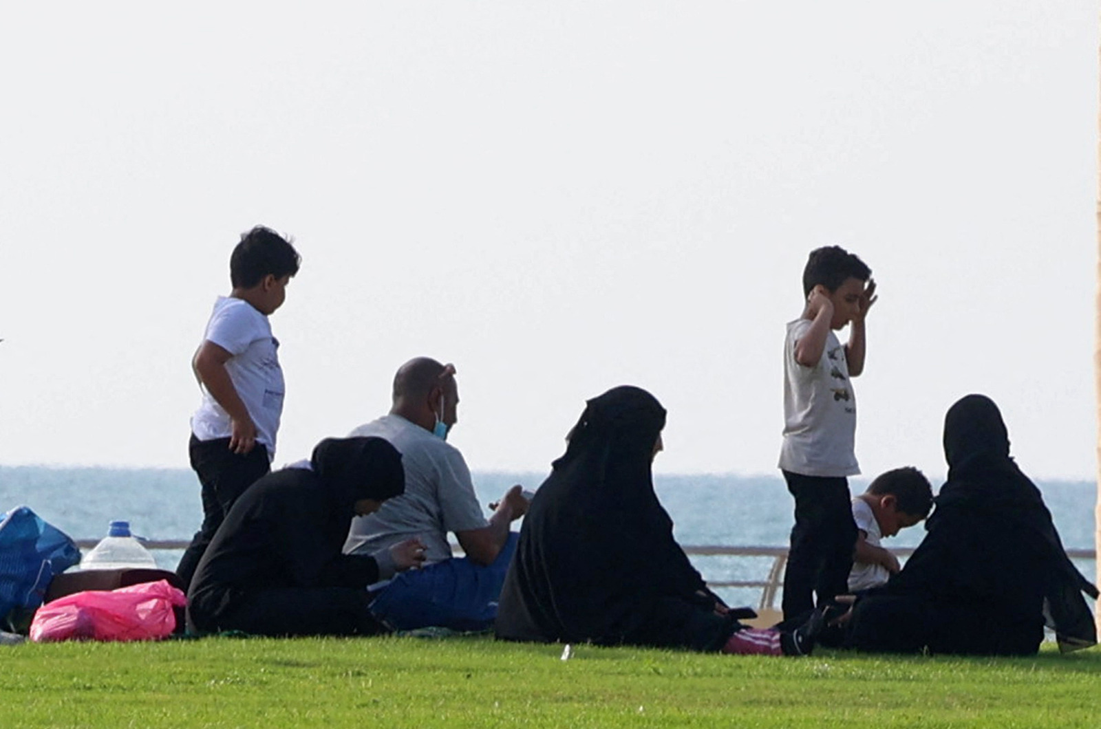 Saudis sit on the corniche, or waterfront promenade, in the Jizan region of southwest Saudi Arabia near the Yemeni border on January 26, 2021.