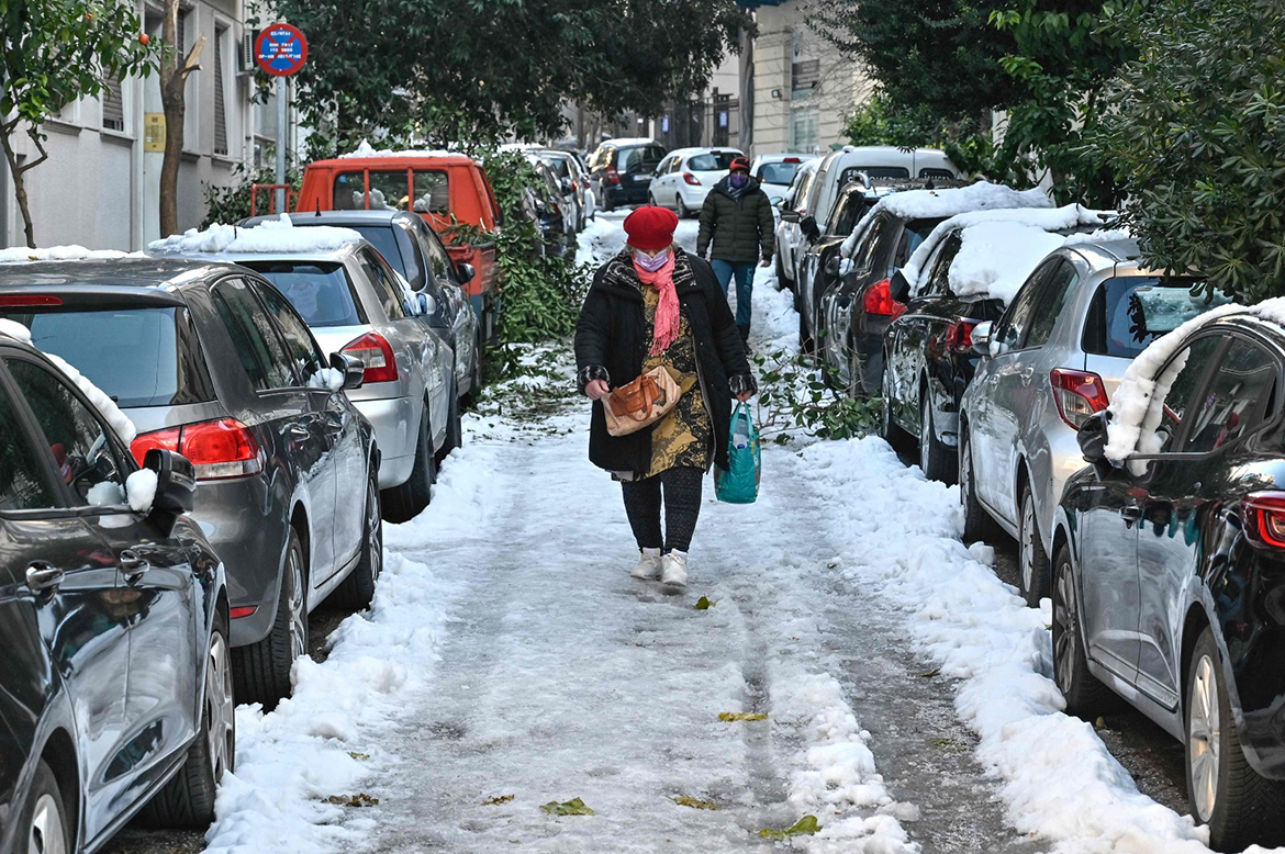 ATHENS: A woman walks on an ice-covered street in central Athens yesterday following heavy snowfall. - AFP