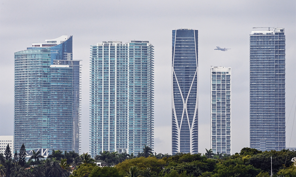 MIAMI, US: A plane flies over Miami residential towers in Miami, Florida. The increase in real estate prices in South Florida is one of the highest in the US. — AFP