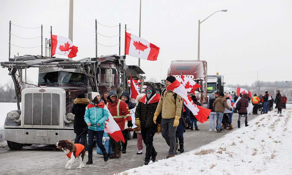 TORONTO: Supporters  for a convoy of truckers driving from British Columbia to Ottawa in protest of a COVID-19 vaccine mandate for cross-border truckers, gather near a highway overpass outside of Toronto, Ontario. —AFP