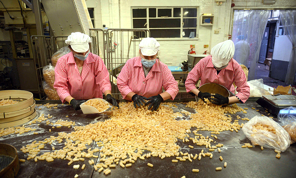 Members of staff at the traditional sweet manufacturer Edward Grays of Dudley gather freshly-made Grays Herbal Tablets.