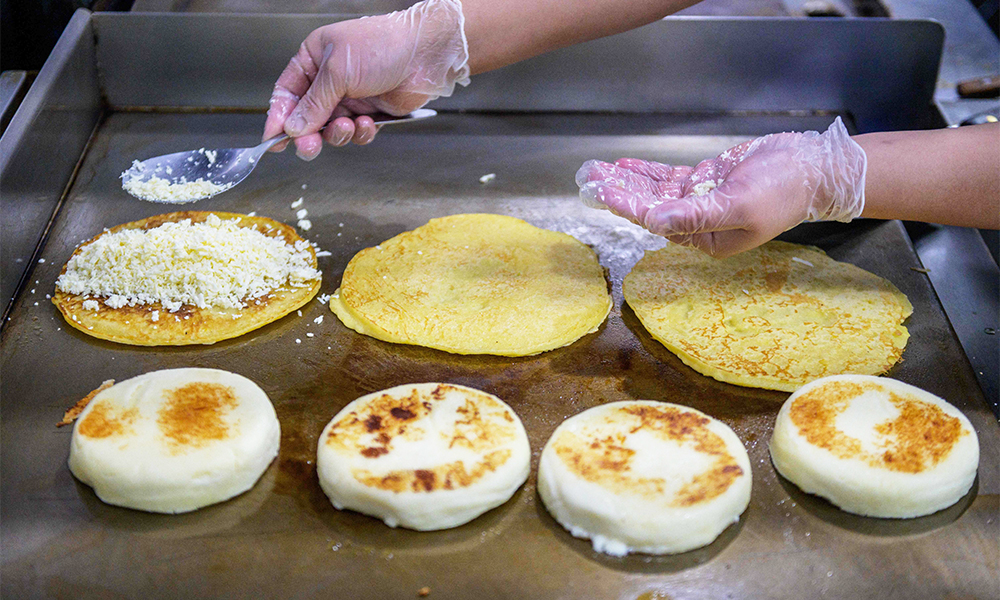 A cook prepares arepas in the kitchen of the Arepa Lady restaurant in the Queens borough of New York City.