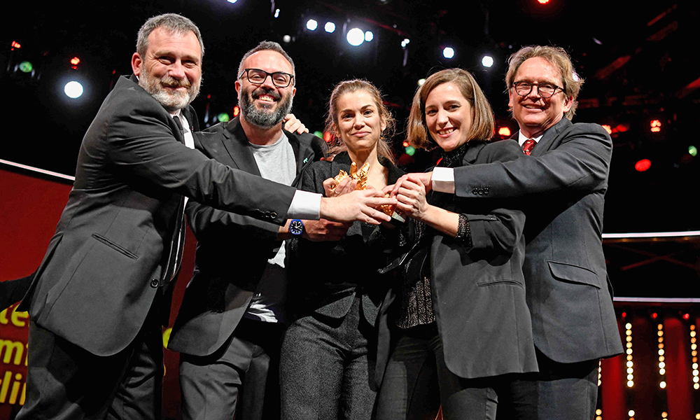 Spanish director and screenwriter Carla Simon (second right), producer Maria Zamora (center) and team members pose with the Golden Bear for Best Film for “Alcarras” during the awards ceremony of the 72nd Berlinale Film Festival. — AFP photos