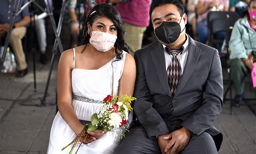 A couple is seen during a collective wedding celebration at the esplanade of the Municipal Palace of Nezahualcoyotl in Nezahualcoyotl, Mexico.