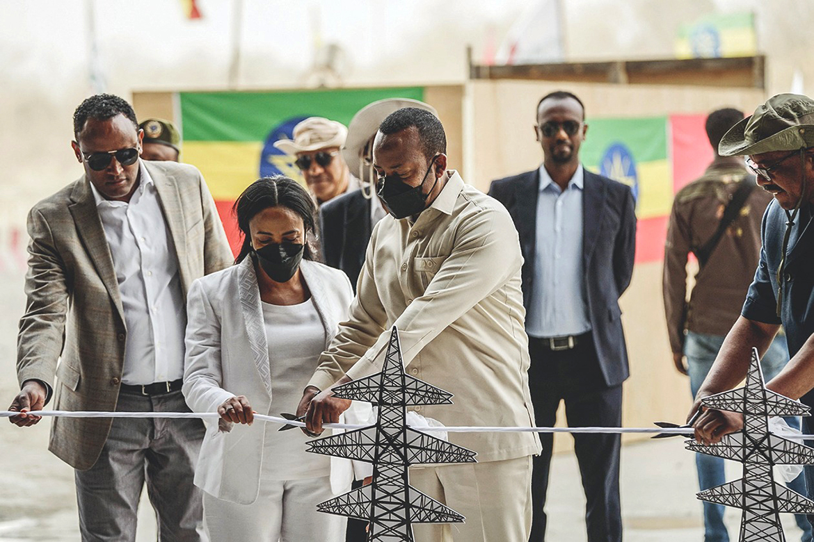 GUBA, Ethiopia: Ethiopian Prime Minister Abiy Ahmed cuts the ribbon during the first power generation ceremony at the site of the Grand Ethiopian Renaissance Dam (GERD) yesterday. - AFP