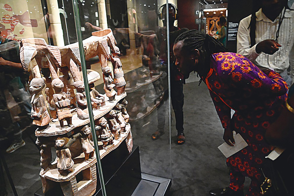 A man looks at Cana throne, a sacred town some 12 miles away from Abomey kingdom looted by French colonial soldiers displayed during an exhibition of returned seized Benin artefacts and exhibition of contemoprary artworks at the presidency in Benin's capital Cotonou.-AFP photos