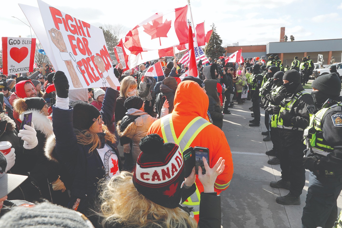 WINDSOR, Canada: Protestors confront the Ontario Provincial Police as they try to clear the entrance to the Ambassador Bridge in Windsor, Ontario, Canada Saturday.-AFP