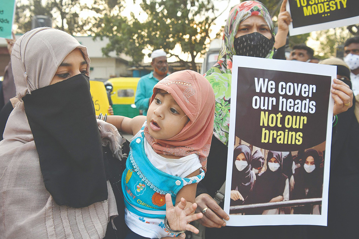 BANGALORE, India: Muslim women hold placards during a demonstration after educational institutes in Karnataka denied entry to students for wearing hijabs, in Bangalore. - AFP