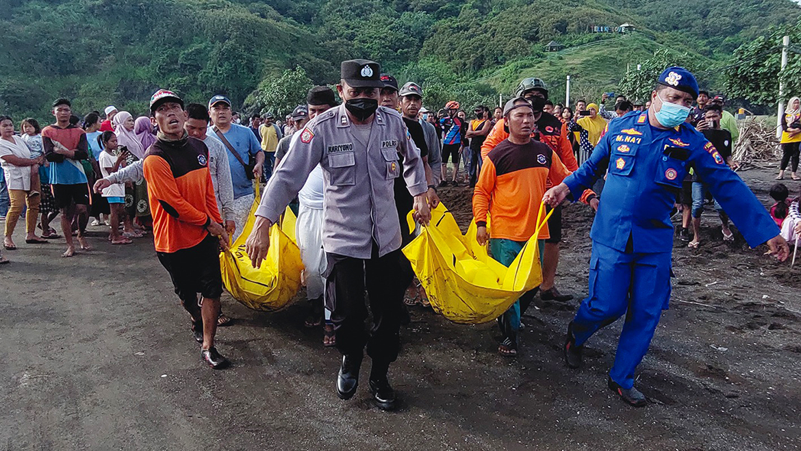 JEMBER,  Indonesia : Indonesian members of a search and rescue team evacuate dead bodies during a search operation following a beach ritual accident that killed ten people in Jember, East Java yesterday. - AFP