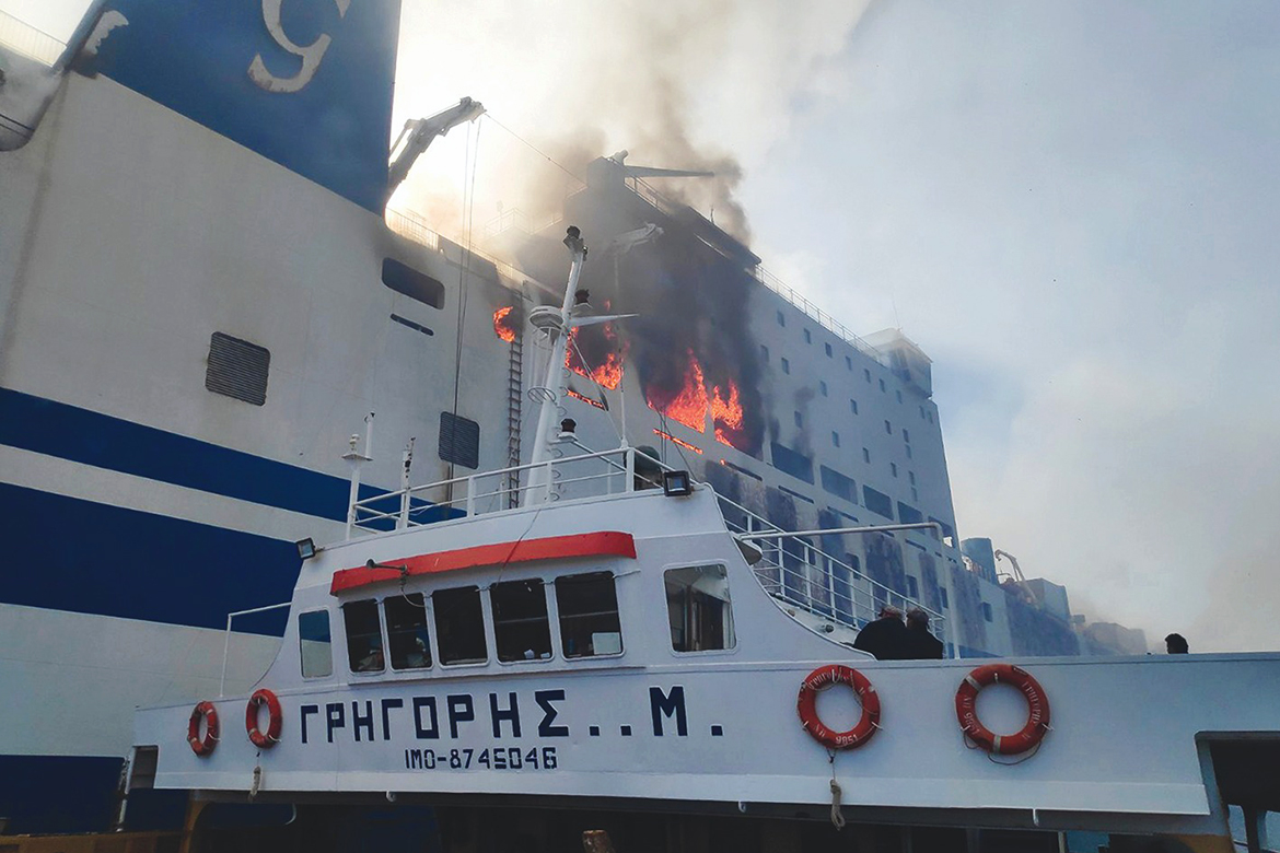CORFU, Greece: This handout picture released by the Greek Fire service shows a vessel approaching the burning Euroferry Olympia near the Greek island of Corfu on Friday. - AFP