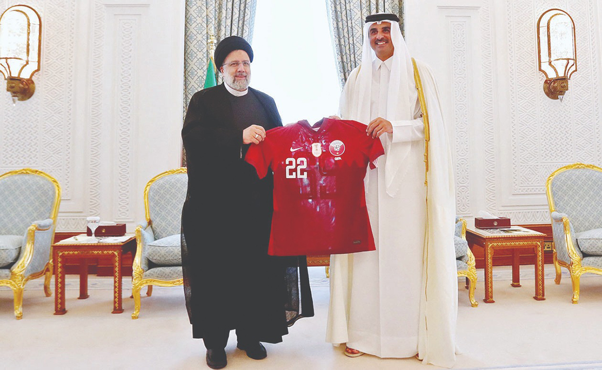 DOHA: Qatari Amir Sheikh Tamim bin Hamad Al-Thani presents Iranian President Ebrahim Raisi with the football jersey of Qatar's national team during their meeting yesterday. - AFP