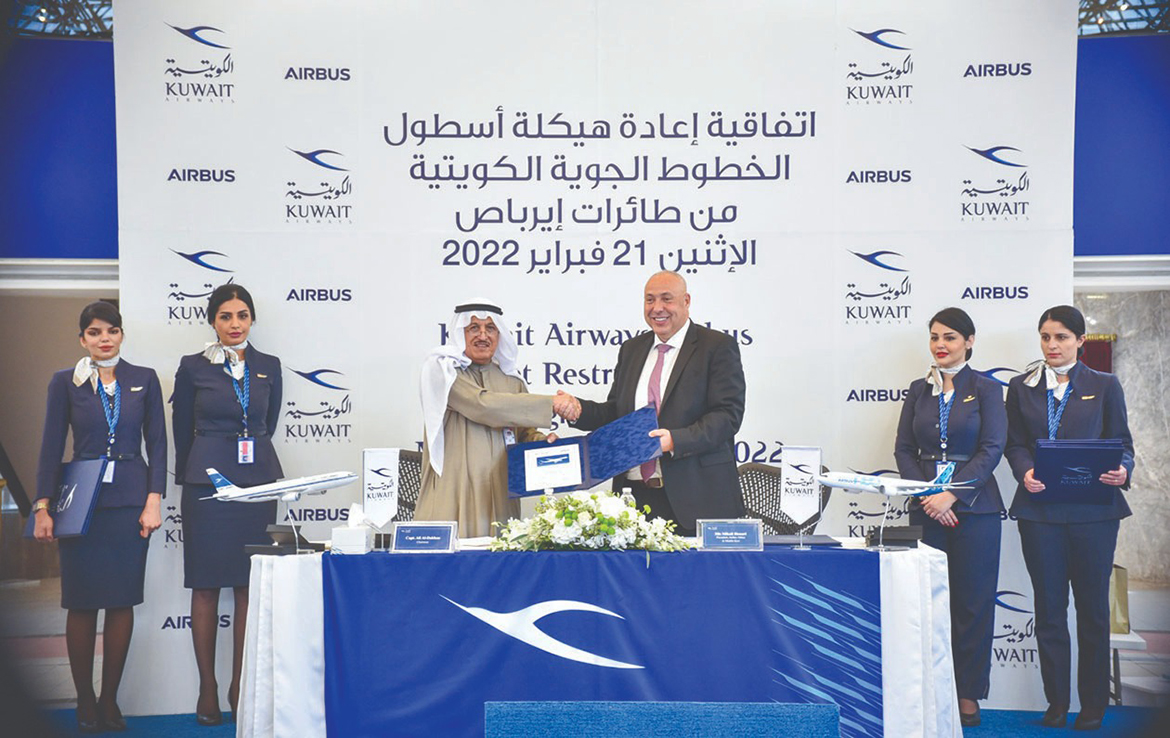 KUWAIT: Chairman of Kuwait Airways Ali Al-Dukhan shakes hands with President of Airbus Africa and Middle East Mikail Houari after signing a deal at the Kuwait Airways headquarters yesterday. - AFP