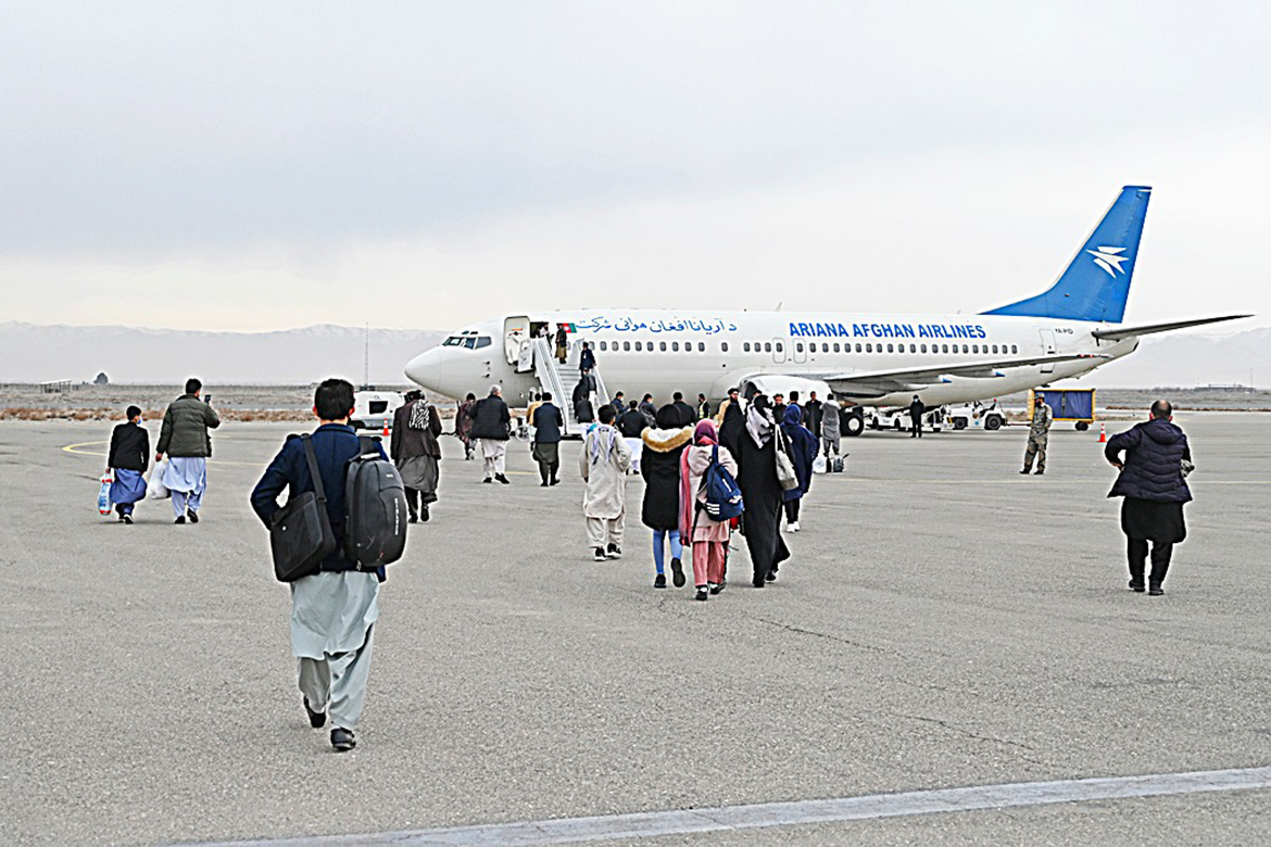 HERAT, Afghanistan: Afghan passengers board a commercial aircraft bound to Kabul, at Herat Airport, some 10 km southeast of Herat yesterday. — AFP
