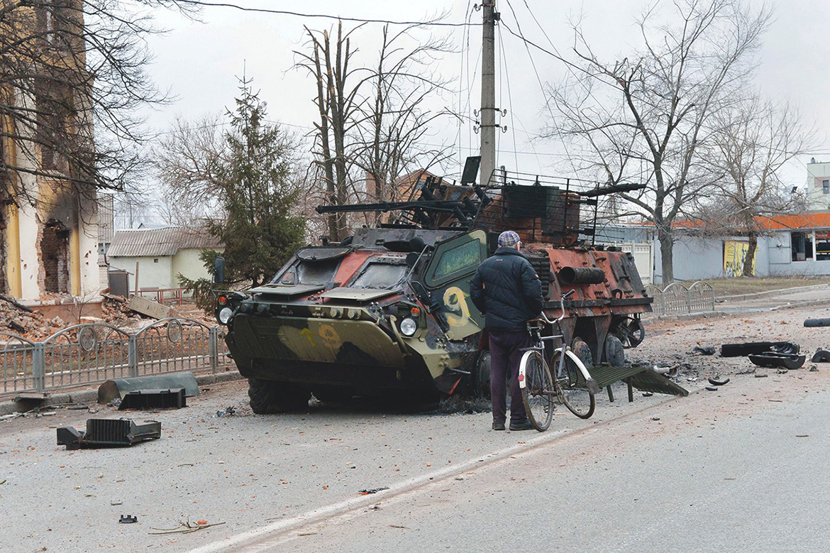 KHARKIV: A man looks at a Ukrainian armored personnel carrier destroyed as a result of a fight not far from the center of this city located some 50 km from the Ukrainian-Russian border yesterday. - AFP