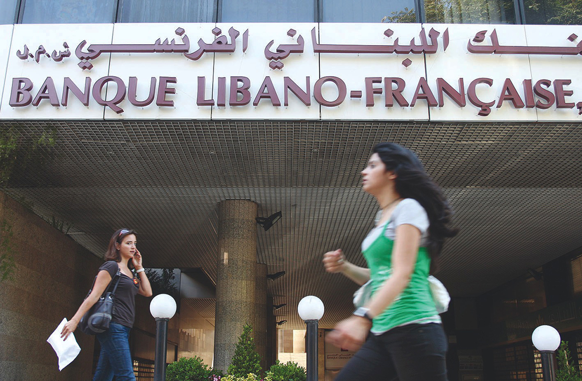 BEIRUT:  Lebanese women walk past a branch of the Banque Libano-Francaise in Beirut.-AFP