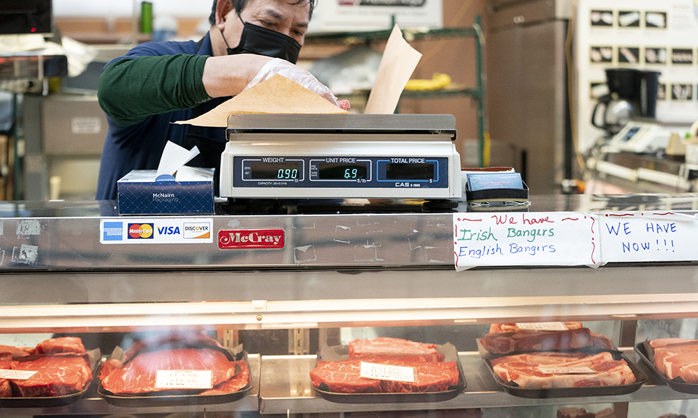 WASHINGTON: An employee weighs a cut of meat for a customer at Canales Quality Meats in Eastern Market in Washington, DC. — AFP